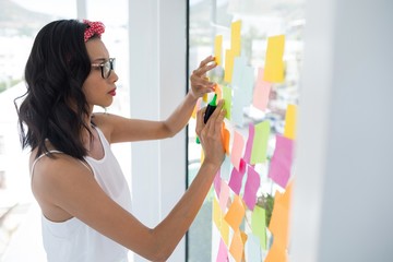 Female executive writing on sticky notes