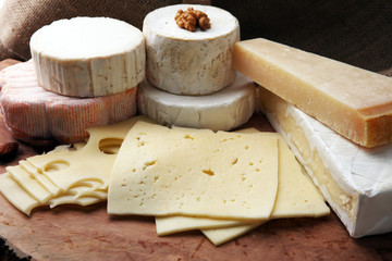 Cheese platter with different cheese on brown wooden plate