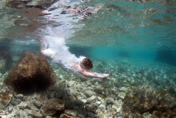 Fototapeta na wymiar Beautiful healthy girl swims in the sea.
