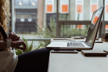 Female executive using smartwatch at desk