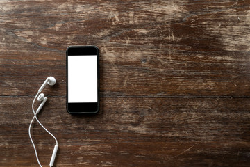 blank screen smart phone mock up and head phone,gadget on table top view,copy space for text,vintage tone