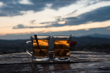 Two glasses of turkish tea on a table on a sunset