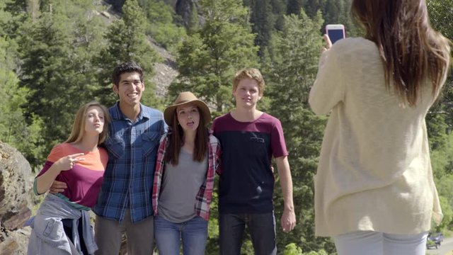 Teen Girl Takes A Few Photos Of Her Friends On Top Of A Mountain, Her Friends Get Distracted When Their Other Friend Arrives 