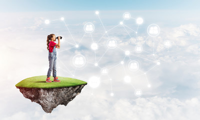 Concept of careless happy childhood with girl looking in binoculars