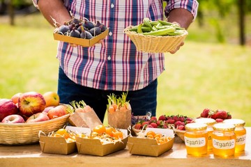 Midsection of man selling figs and okras