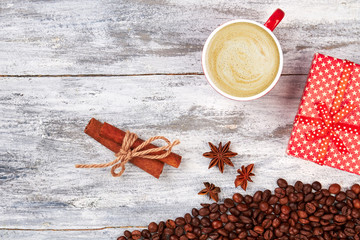 Cup of coffee, wooden background. Cinnamon and gift box. Be grateful with coffee.