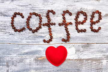 Fototapeta premium Word coffee from grain. Fabric heart on wooden background. With love for gourmet.