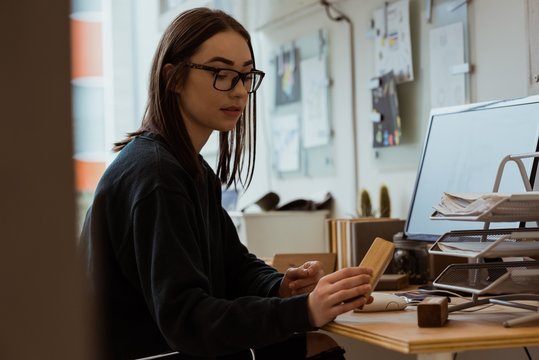 Female executive examining wooden slab at desk
