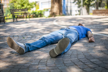 giovane a terra incosciente e svenuto in un parco