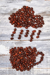 Raindrops from coffee beans. Cup from coffee, wooden background.