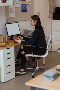 Female executive holding wooden slabs at desk