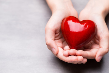 Obraz premium Red wood heart in child hands.