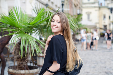 Outdoor portrait of young attractive woman with long blonde hair walking in the city