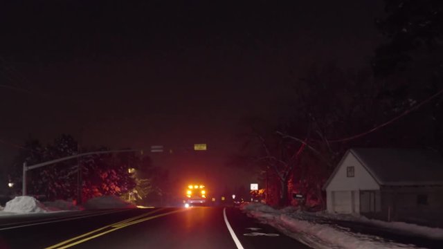 Driver's Perspective Of Fire Engine With Flashing Lights, Driving On Road In Winter At Night
