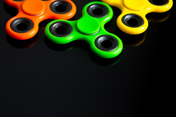 Fidget finger spinner, anxiety relief toy on black background, copyspace. Concept relieving stress
