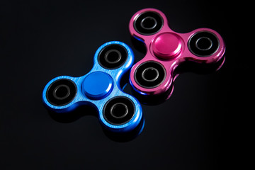 Fidget finger spinner, anxiety relief toy on black background, copyspace. Concept relieving stress