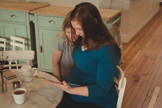 Pregnant mother and daughter looking at menu