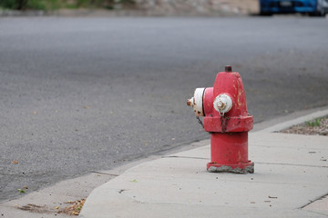 Red and white rusting fire hydrant on street corner