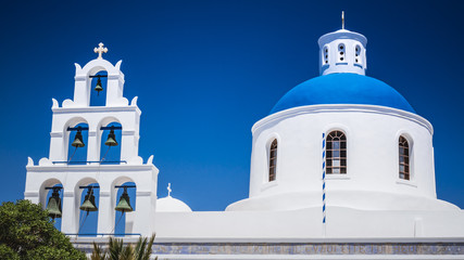 Oia town on Santorini island, Greece. Traditional and famous houses and churches with blue domes over the Caldera, Aegean sea