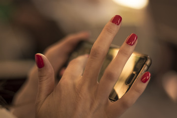 Cropped shot view: woman's hands plays in smart phone