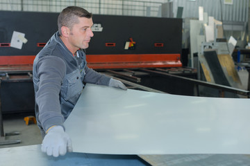 man working at a factory manufacturing tempered clear float glass - obrazy, fototapety, plakaty