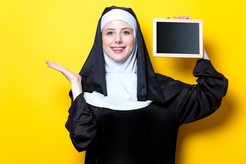 Young smiling nun with board