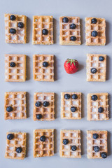 Background of belgian waffles with strawberry and blueberries on the gray background