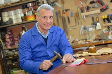 senior carpenter working with a hammer in the workshop
