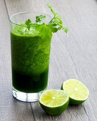 Healthy green vegetable juice on wooden table