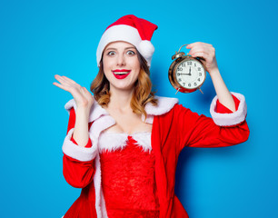 Santa Claus girl in red clothes with  alarm clock