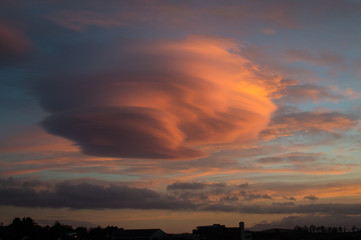 Naklejka premium Soczewkowata chmura o zachodzie słońca