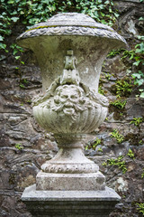 Ornamental stone urn with face