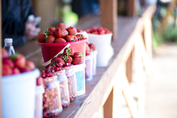 Fresh strawberries in buckets on the shelves