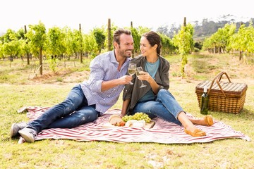 Full length of happy couple toasting wineglasses