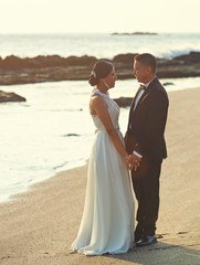 Fototapeta na wymiar Just married couple on ocean beach