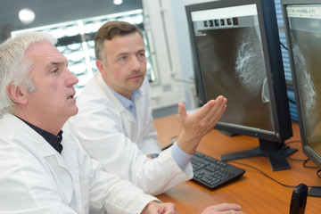 Naklejka premium Medical workers looking at results on computer screen