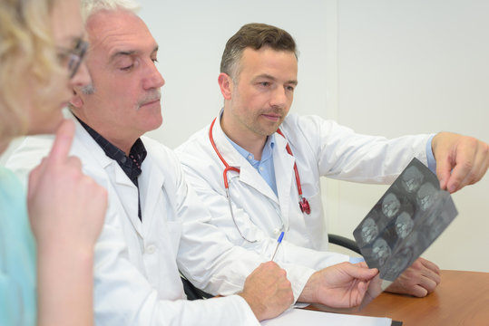 three doctors looking at x-ray
