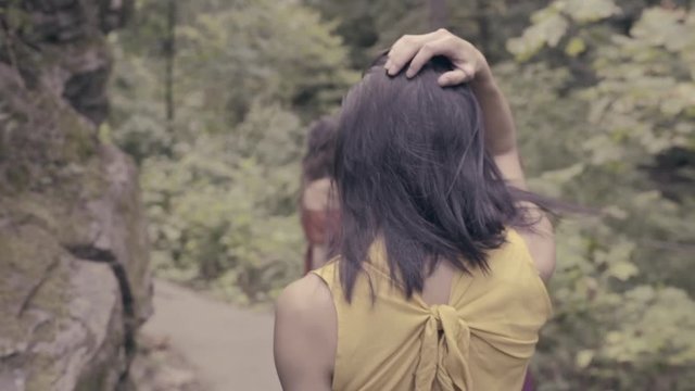 3 Beautiful Models Walk In Forest, Away From Camera, Model Looks Back Over Her Shoulder (Slow Motion)