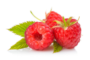 Fresh red raspberries with green leaves isolated on white