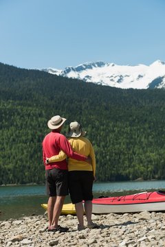 Rear view of mature couple standing at lakeshore