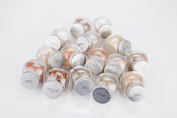 Spice glass containers on a white surface. Spice jars isolated on white background.