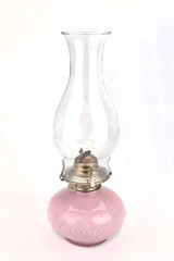 Pink vintage oil lamp on a white surface. Pink antique oil lamp isolated on white background.