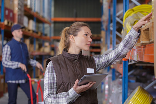 Female Warehouse Worker Checking Stock Of Cables