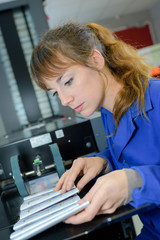 Naklejka premium young woman working in newspaper factory