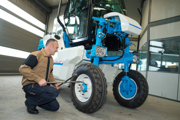 man fixing a tractor in an agro-industrial hardware