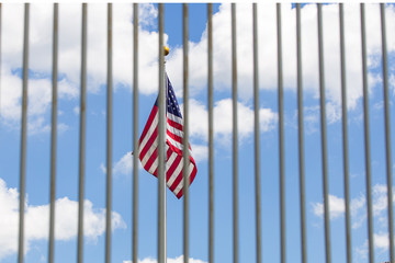 The USA flag visible through fence grates