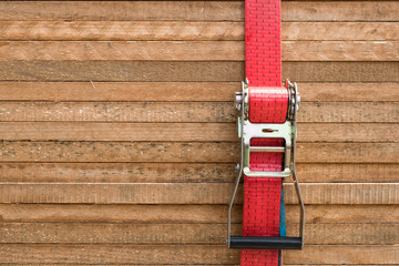 red ratchet strap fixing wood boards / wooden planks