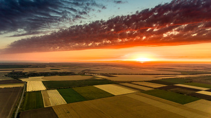 Aerial shot of an agricultural field at a scary sunset in Ukraine in spring