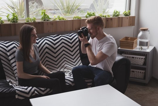 Male photographer photographing woman at home