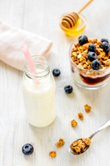 Fitness breakfast with granola, milk and honey on white backgrou